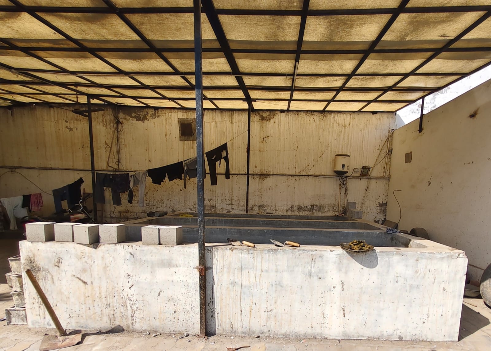 Concrete curing tank under a shade structure
